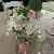 Garden style centerpiece of white hydrangea, pink garden roses, pink stock, variegated pitt, white lissianthus, and pink dahlias